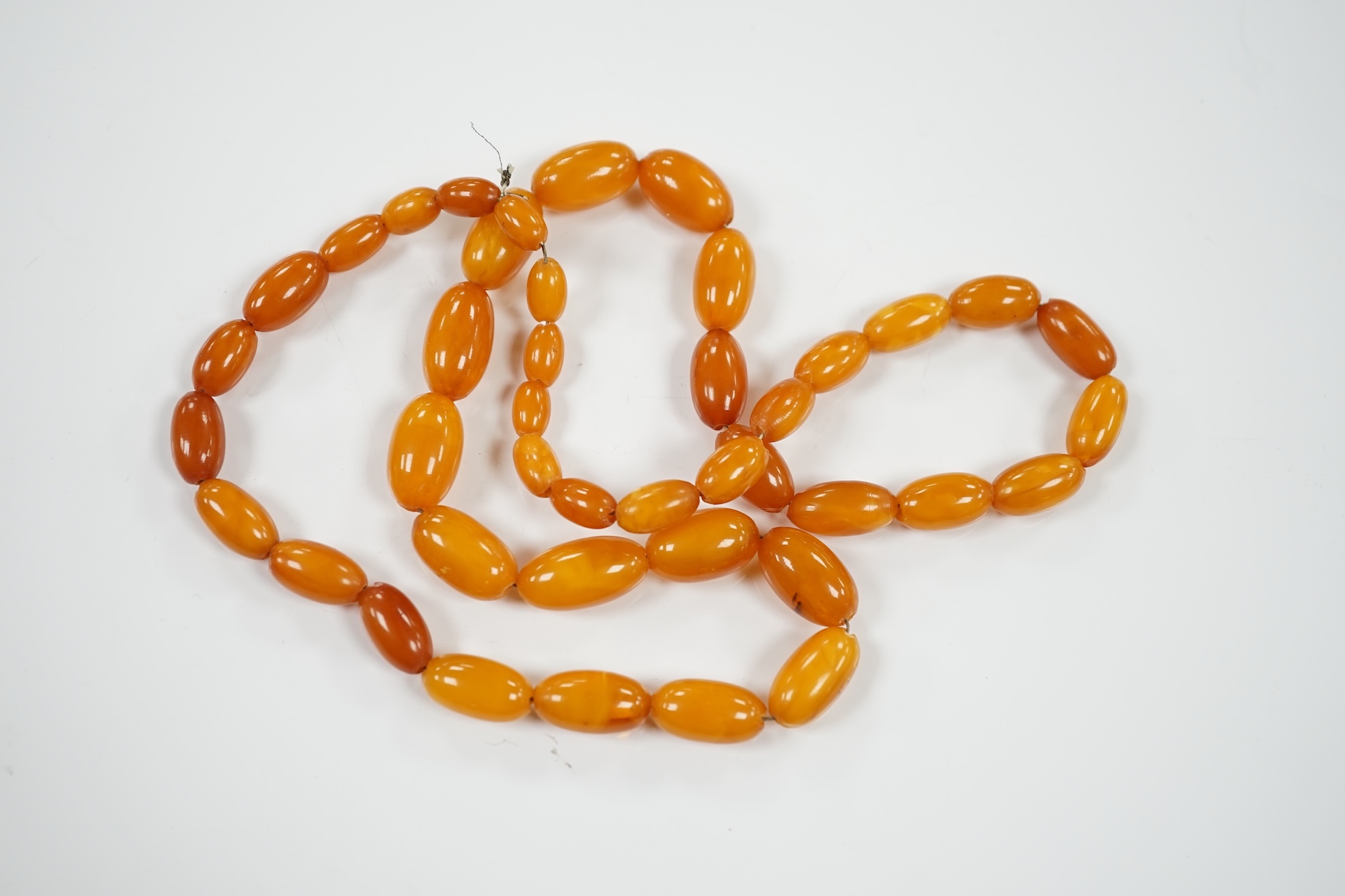 A single strand graduated amber bead necklace, 66cm, gross weight 40 grams. Condition - poor to fair